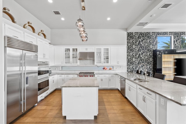 6950 NW 25th Way, Boca Raton, FL 33496 - kitchen featuring appliances with stainless steel finishes, a sink, a peninsula, under cabinet range hood, and white cabinetry