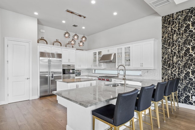 6950 NW 25th Way, Boca Raton, FL 33496 - kitchen featuring appliances with stainless steel finishes, under cabinet range hood, a sink, a center island, and white cabinetry