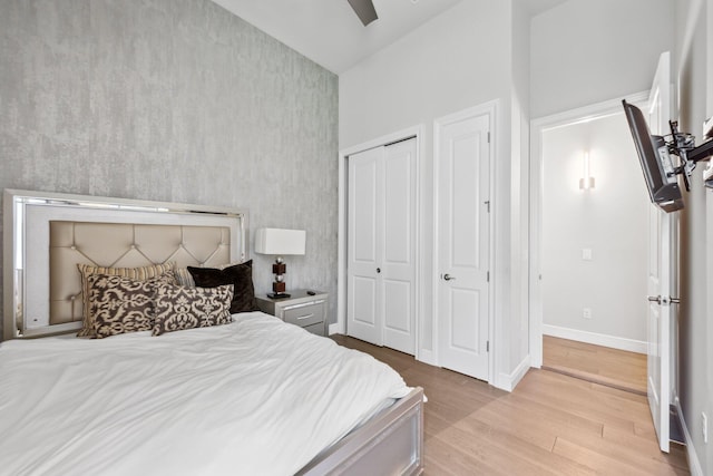6950 NW 25th Way, Boca Raton, FL 33496 - bedroom with light wood-style floors, baseboards, a high ceiling, a ceiling fan, and a closet