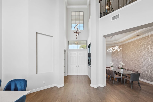6950 NW 25th Way, Boca Raton, FL 33496 - foyer with a chandelier, a towering ceiling, crown molding, baseboards, and wood-type flooring