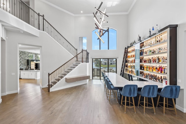 6950 NW 25th Way, Boca Raton, FL 33496 - dining space featuring plenty of natural light, wood finished floors, a towering ceiling, and crown molding