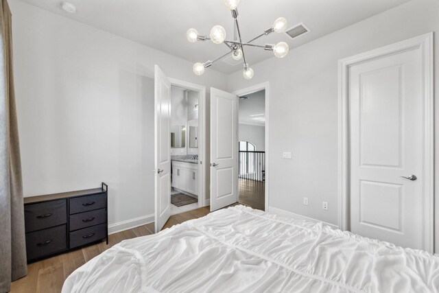 6950 NW 25th Way, Boca Raton, FL 33496 - bedroom featuring a chandelier, wood finished floors, baseboards, and ensuite bath