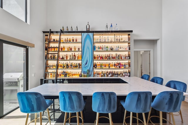 6950 NW 25th Way, Boca Raton, FL 33496 - indoor wet bar featuring a towering ceiling and wood finished floors