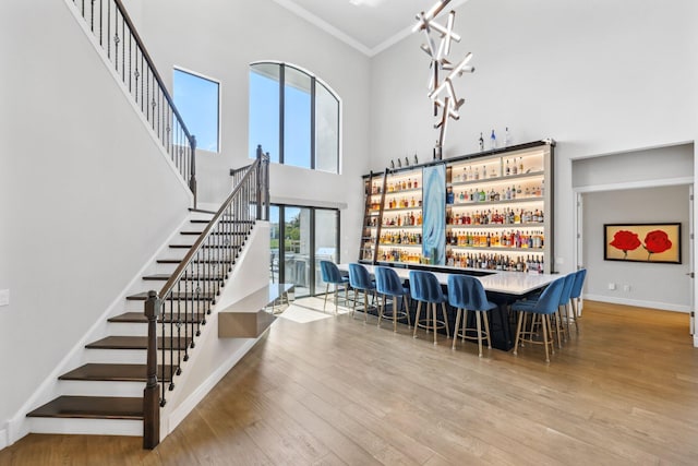 6950 NW 25th Way, Boca Raton, FL 33496 - community bar area with baseboards, crown molding, a towering ceiling, stairway, and wood finished floors