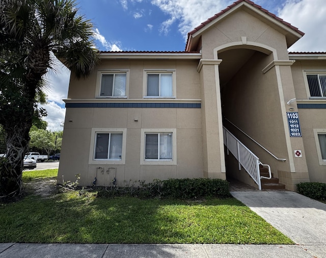 1103 Golden Lakes Blvd Unit 1011, West Palm Beach, FL 33411 - view of front of property featuring stucco siding and a front lawn
