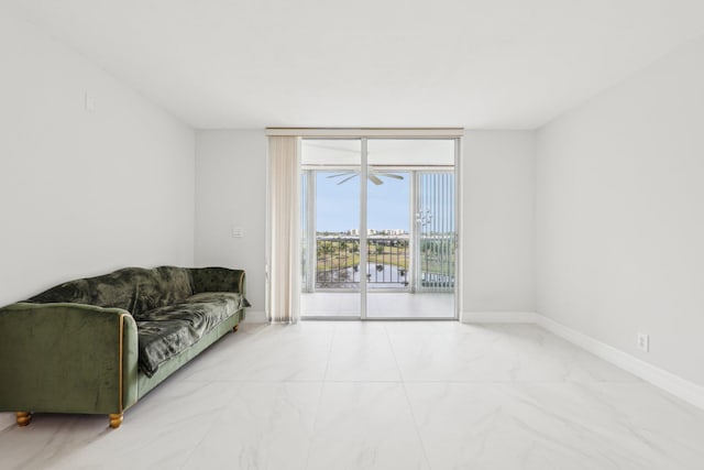 living area with baseboards, floor to ceiling windows, and marble finish floor