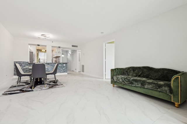 living area featuring visible vents, marble finish floor, and baseboards