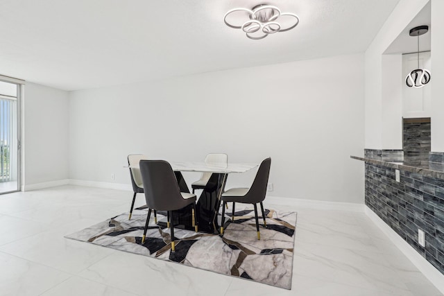 dining room with baseboards and marble finish floor