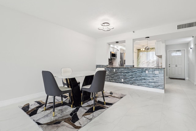 dining room with baseboards, visible vents, and marble finish floor