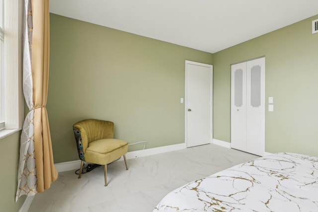bedroom with baseboards, visible vents, marble finish floor, and a closet