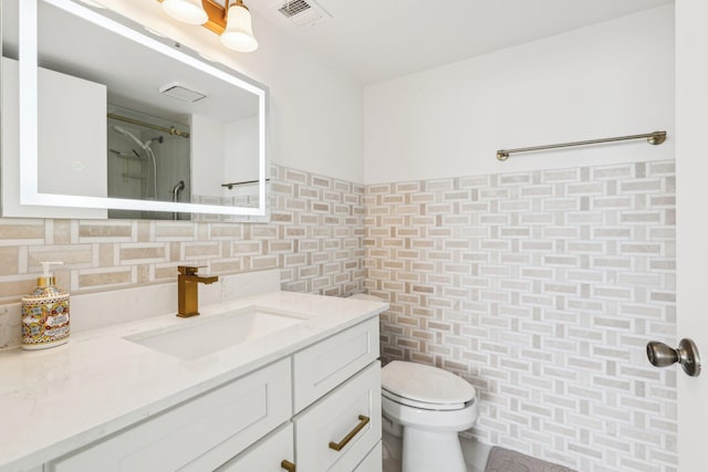 bathroom with backsplash, visible vents, tile walls, vanity, and toilet
