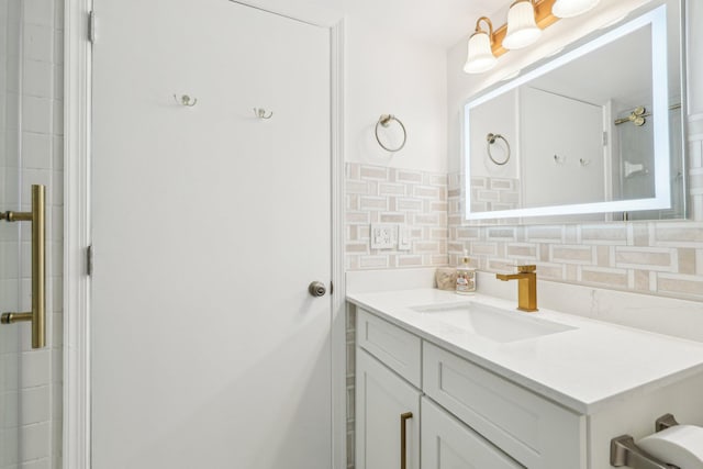 full bathroom with vanity, tasteful backsplash, and a shower with door