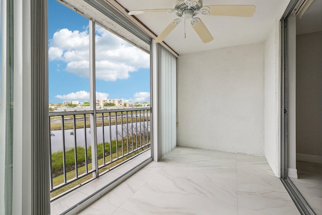 balcony with a water view and a ceiling fan