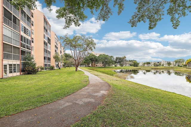 surrounding community with a lawn and a water view