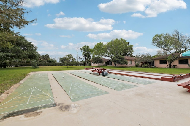 view of home's community with a lawn and shuffleboard