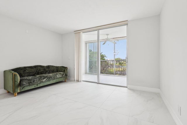 sitting room featuring baseboards, expansive windows, and marble finish floor