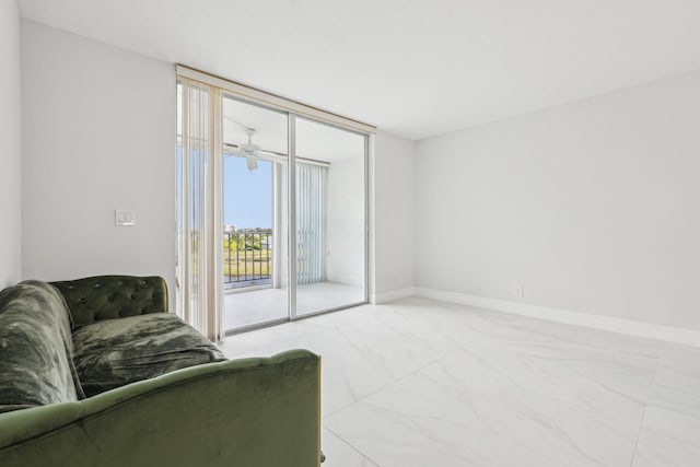 living area with baseboards, floor to ceiling windows, and marble finish floor