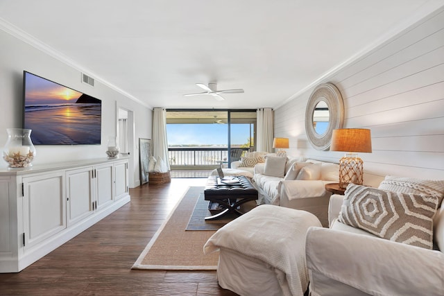 living area with visible vents, ornamental molding, dark wood-style flooring, a water view, and expansive windows