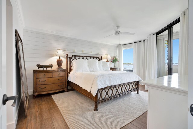 bedroom with access to outside, a ceiling fan, and dark wood finished floors
