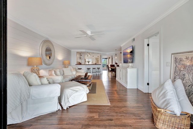 living room with ornamental molding, a ceiling fan, dark wood-style flooring, and visible vents