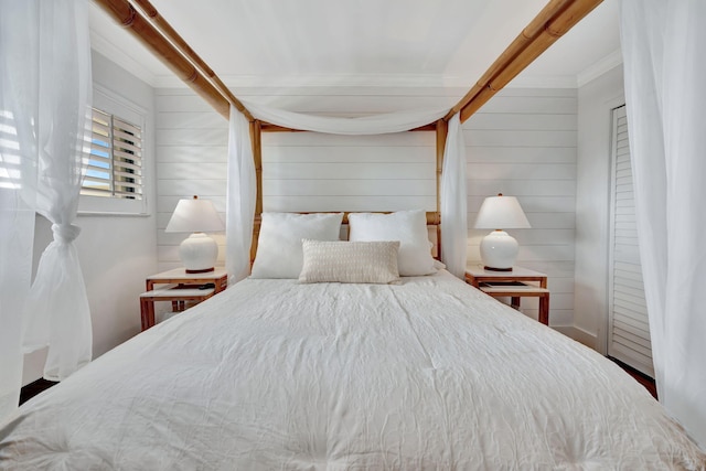 bedroom with crown molding and wooden walls
