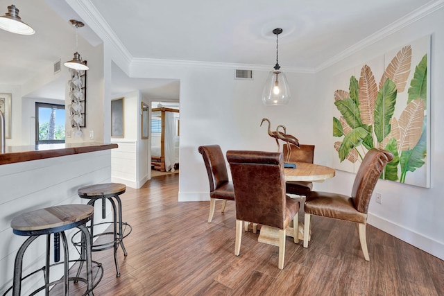 dining room with baseboards, visible vents, and wood finished floors
