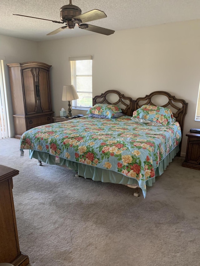 bedroom featuring a textured ceiling, a ceiling fan, and carpet floors