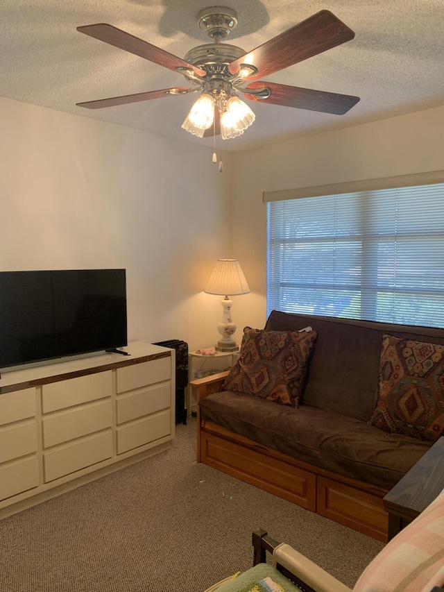 living room featuring a ceiling fan, light carpet, and a textured ceiling