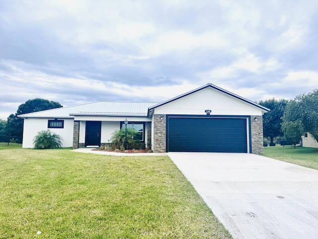 single story home featuring a garage, a front lawn, and stone siding