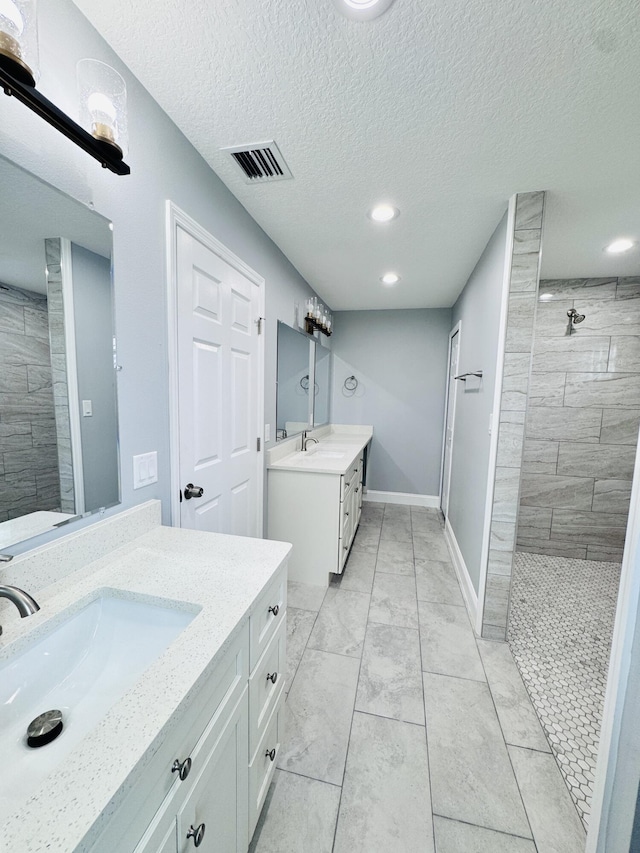 full bath with a walk in shower, a sink, recessed lighting, two vanities, and visible vents