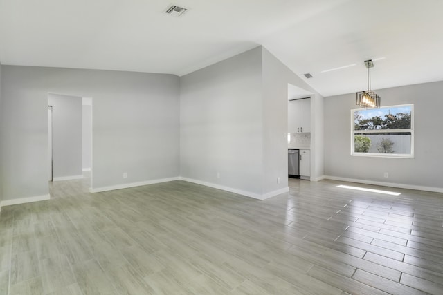 2732 Starwood Cir, West Palm Beach, FL 33406 - unfurnished living room with vaulted ceiling, light wood-style floors, baseboards, and a chandelier