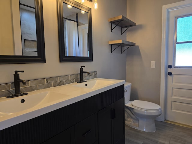 2732 Starwood Cir, West Palm Beach, FL 33406 - full bathroom featuring toilet, double vanity, and wood finished floors