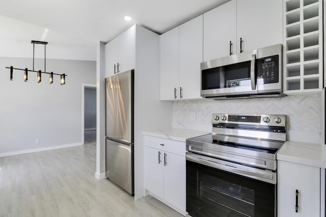 2732 Starwood Cir, West Palm Beach, FL 33406 - kitchen featuring stainless steel appliances, tasteful backsplash, baseboards, white cabinetry, and light wood finished floors