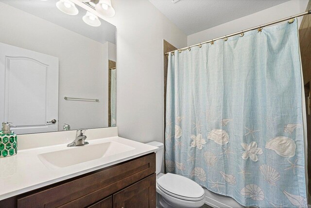 12949 Anthorne Ln, Boynton Beach, FL 33436 - bathroom featuring vanity, toilet, a textured ceiling, and a shower with shower curtain
