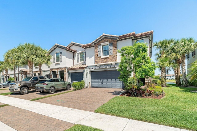12949 Anthorne Ln, Boynton Beach, FL 33436 - view of front of home featuring stone siding, decorative driveway, stucco siding, a tiled roof, and an attached garage