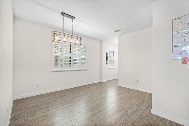 12949 Anthorne Ln, Boynton Beach, FL 33436 - unfurnished room featuring a textured ceiling, baseboards, visible vents, and wood finished floors