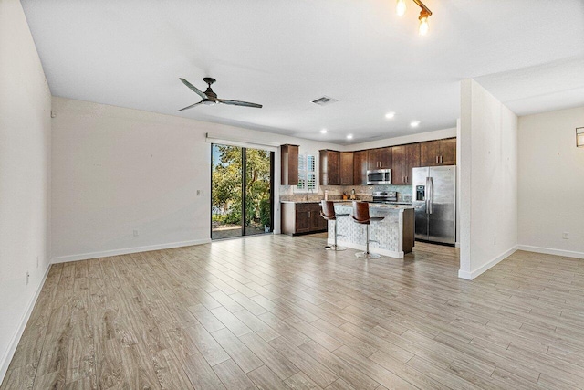 12949 Anthorne Ln, Boynton Beach, FL 33436 - unfurnished living room with baseboards, a ceiling fan, light wood-style flooring, and visible vents