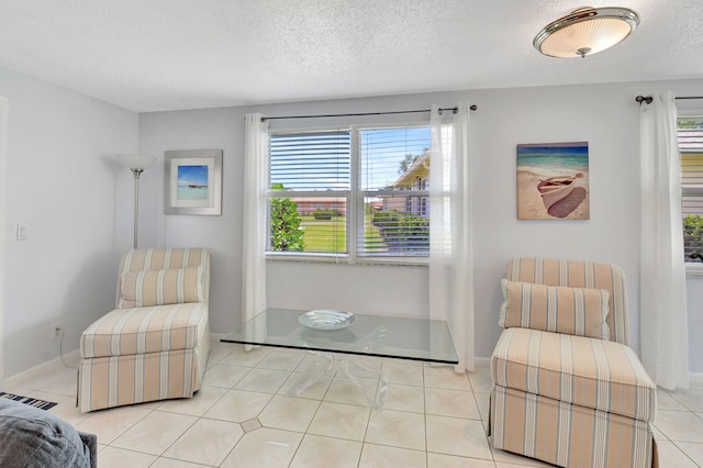 124 Mockingbird Ln Unit 124, Delray Beach, FL 33445 - living area featuring healthy amount of natural light, a textured ceiling, baseboards, and light tile patterned flooring