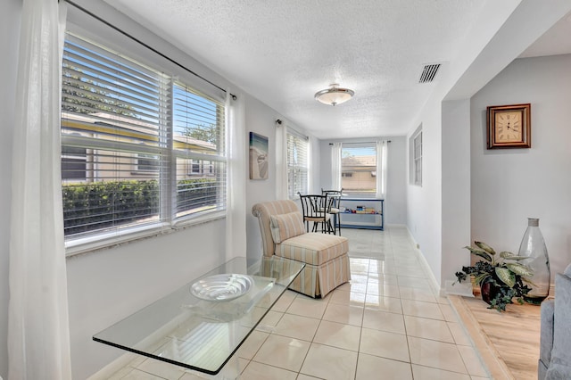124 Mockingbird Ln Unit 124, Delray Beach, FL 33445 - sitting room featuring a textured ceiling, baseboards, and light tile patterned floors