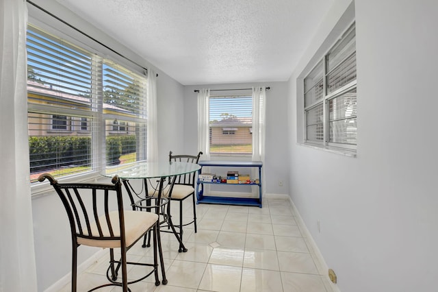 124 Mockingbird Ln Unit 124, Delray Beach, FL 33445 - dining space featuring a textured ceiling, light tile patterned flooring, and baseboards