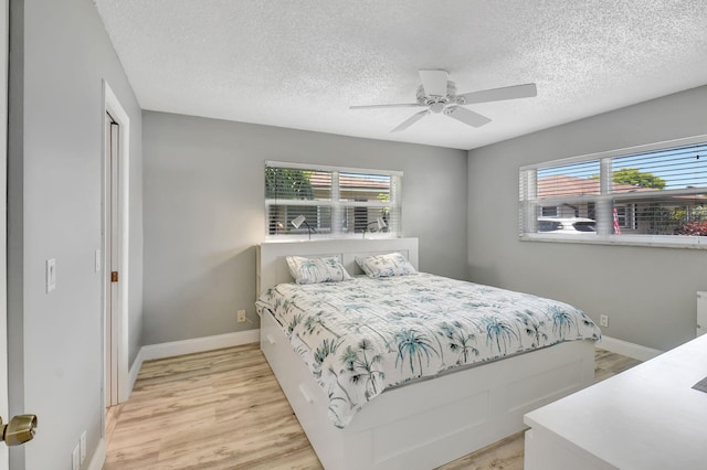 124 Mockingbird Ln Unit 124, Delray Beach, FL 33445 - bedroom featuring light wood finished floors, multiple windows, a textured ceiling, and baseboards