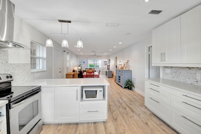 124 Mockingbird Ln Unit 124, Delray Beach, FL 33445 - kitchen with electric stove, wall chimney exhaust hood, a peninsula, white microwave, and light countertops