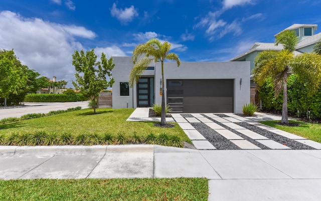 188 Yale Dr, Lake Worth Beach, FL 33460 - contemporary home featuring an attached garage, stucco siding, driveway, and a front lawn