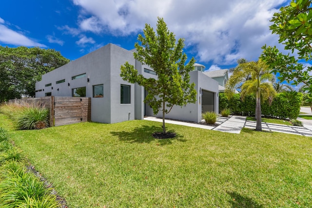 188 Yale Dr, Lake Worth Beach, FL 33460 - back of property featuring a yard, stucco siding, fence, and an attached garage