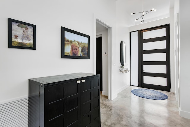 188 Yale Dr, Lake Worth Beach, FL 33460 - foyer featuring a chandelier, concrete flooring, and baseboards