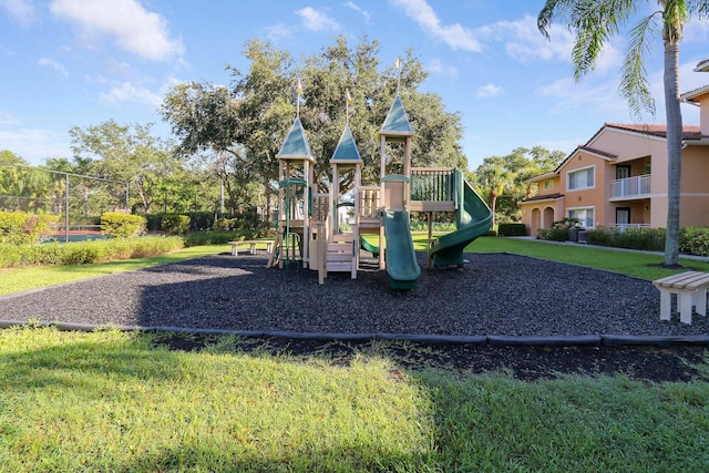 community play area with a lawn and fence
