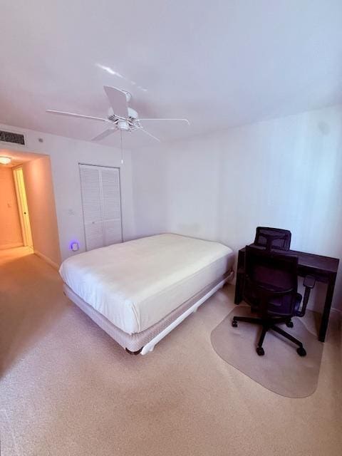 carpeted bedroom with ceiling fan, a closet, and visible vents