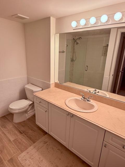 242 Village Blvd Unit 2203, Tequesta, FL 33469 - full bath with a shower stall, vanity, wood finished floors, and toilet