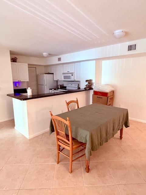 dining space with light tile patterned floors and visible vents