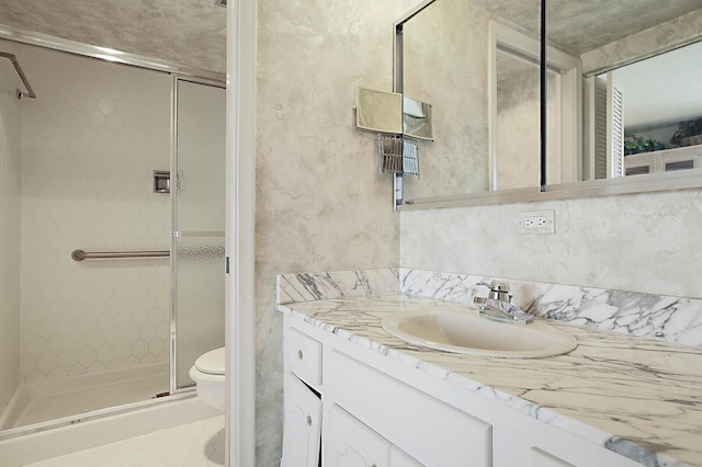 full bath featuring vanity, a shower stall, and toilet